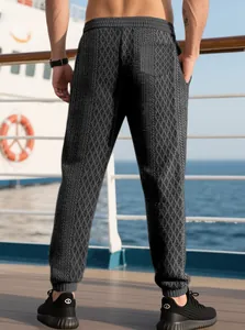 Detail of men's slim fit dark grey joggers featuring intricate jacquard diamond texture