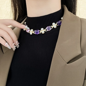 Collier vintage doré avec pierre violette et perle blanche porté par un mannequin