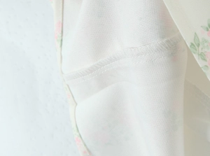 Gros plan détaillé montrant la couture de surjet et la texture du tissu tissé floral