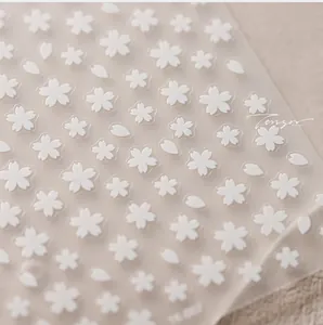 Close-up of 3D embossed white cherry blossom nail stickers with floral petal details