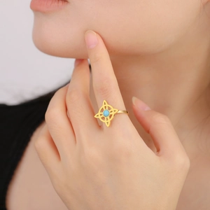 Close-up of a vintage stainless steel witch knot ring with blue turquoise gemstone