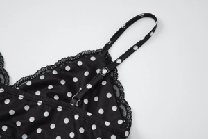 Dettaglio delle spalline regolabili e pizzo nero sul top a pois stile camisole