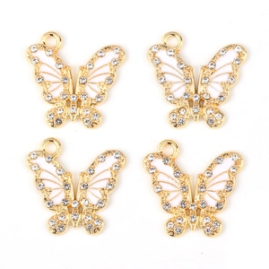 Detailed view of four golden butterfly pendants with white enamel and sparkling rhinestones