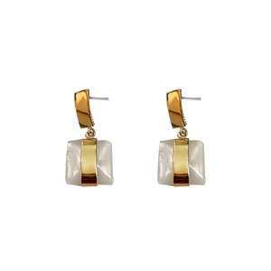 Boucles d'oreilles pendantes géométriques dorées avec incrustation en résine blanc crème