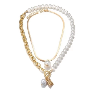 Close-up of double-layered snake chain and baroque pearl necklace with gold square pendant