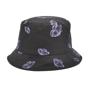 Détail d'un chapeau bob en coton noir avec imprimé papillon violet et texture en sergé