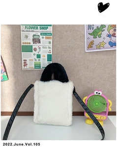 Detail of soft white faux fur plush panda bag with black handles and detachable strap