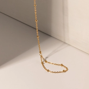 Detail of 18k gold plated stainless steel bead chain necklace with polished golden beads