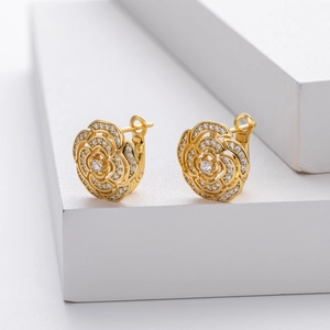 Macro detail of gold camellia flower earrings with micro-set zircon on petals