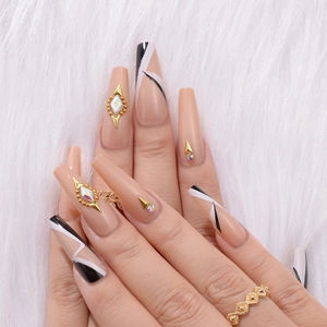 Detailed view of long ballerina fake nails with nude base, geometric lines and rhinestones