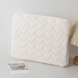 Detail of heart quilted laptop sleeve with metallic round zipper and soft texture