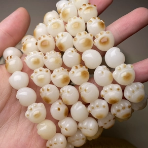 Macro shot of cat paw shaped beads featuring white stone and soft brown accents