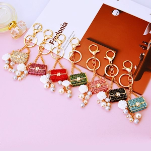 Close-up of pearl handbag keychains with crystals and rose charms in seven colors