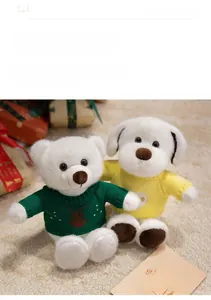 Détail de l'ours et chiot en peluche portant des pulls tricotés sur un fond chaleureux