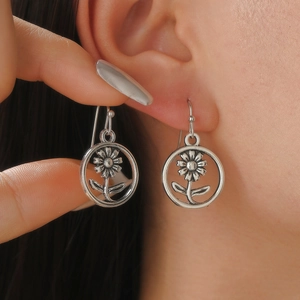 Close-up of vintage silver floral drop earrings featuring intricate flower and leaf detail