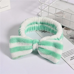 Detail of mint green and white striped coral fleece headband with large bow tie