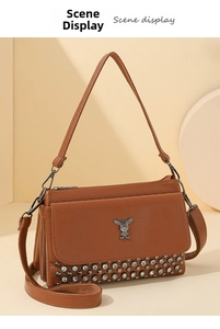 Detail of vintage brown leather bag with silver rivets and rabbit logo in studio setting