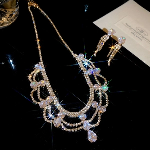 Dettaglio del set di gioielli dorati con collana a strati ed eleganti orecchini a frangia