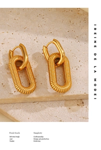 Detail of 18K gold plated stainless steel chunky oval chain earrings on stone surface
