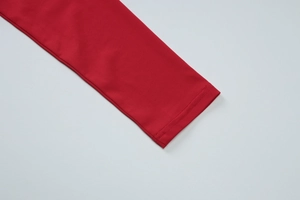 Détail de la manche du top rouge asymétrique avec une couture double aiguille précise