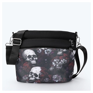 Detail view of double zippers and gothic skull floral print on black crossbody bag