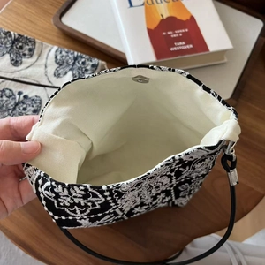 Détails du fermoir magnétique et de la broderie sur un sac bandoulière en toile