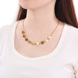 Close-up of golden stainless steel necklace with flat oval links on a female model
