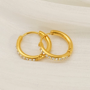 Elegant 18K gold plated hoop earrings with shimmering crystals on soft white fabric