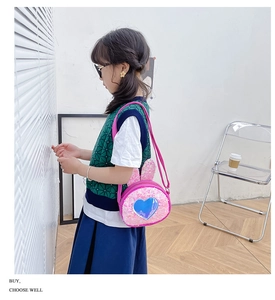 Pink sequin bunny ear crossbody bag for girls with heart window shown on a child model
