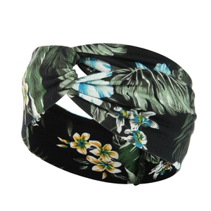 Detail of a black twisted headband featuring a vibrant tropical floral pattern and soft fabric