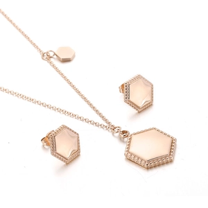 Rose gold geometric hexagon necklace and earrings set with beaded edge detail on white background