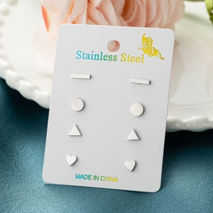 Set of four minimalist stainless steel geometric stud earrings on a display card