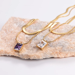Macro detail of rectangle purple and white zircon pendants on 18K gold snake chain