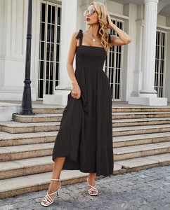 Detail of elegant black sleeveless tiered maxi dress with lace-up shoulder straps