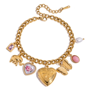 Detail of vintage gold stainless steel bracelet with diverse charms and pink stone inlay