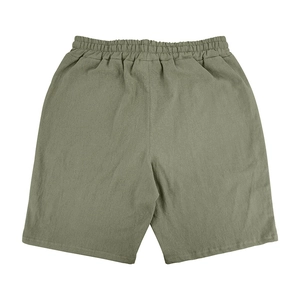 Detail of green men's linen shorts showing elastic waistband and breathable woven texture