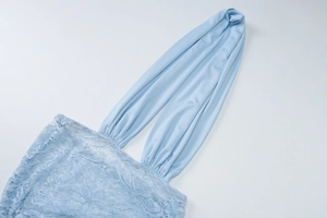 Dettaglio di pizzo azzurro e spalline allacciate al collo su questo abito elegante