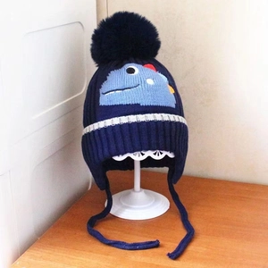 Navy blue kids knit beanie with blue dinosaur patch and large pompom on top
