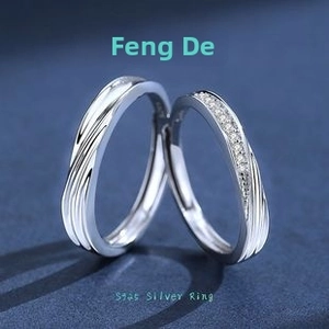 Detail of S925 sterling silver Mobius rings with sparkling cubic zirconia on blue surface