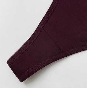 Close-up of wine red ribbed knit fabric and reinforced stitching for thong underwear