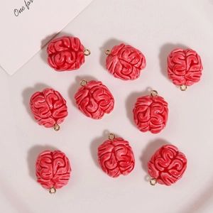 Flat lay of nine red resin brain charms with gold loops for DIY jewelry making
