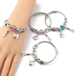 Detail of silver cable wire bangles set with heart charms and faceted crystal beads