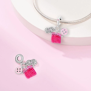 Detailed view of silver knitting theme charms with pink enamel and sparkling crystals