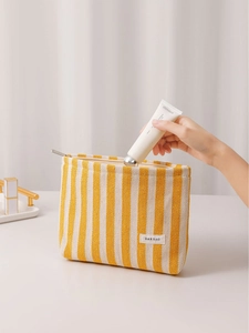 Striped canvas cosmetic bag with yellow stripes shown in a professional usage scene