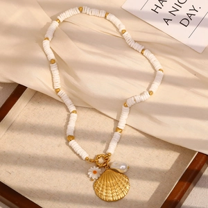 Vue macro du collier en nacre avec perles blanches, pendentif coquillage et détails perle
