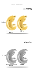 Detail view of chunky C-shaped hoop earrings in polished gold and silver mirror finish