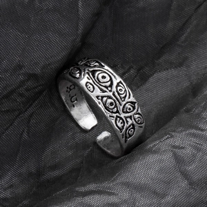Detail of vintage adjustable animal ring featuring intricate engraved eye patterns