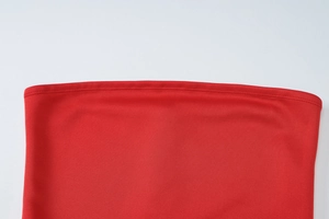 Close-up of the red dress fabric showing high-quality double-stitch seam and texture