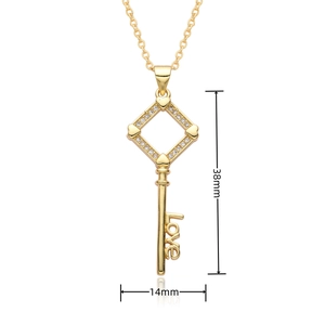 Detailed view of an 18k gold heart key pendant with crystals and Love engraving