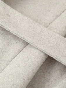 Détail macro de la texture du feutre de laine gris et des coutures durables du manteau